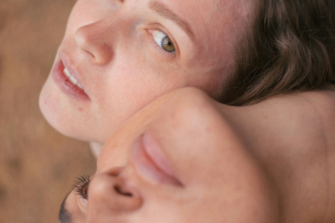 A woman resting her head, eyes open, in warm light